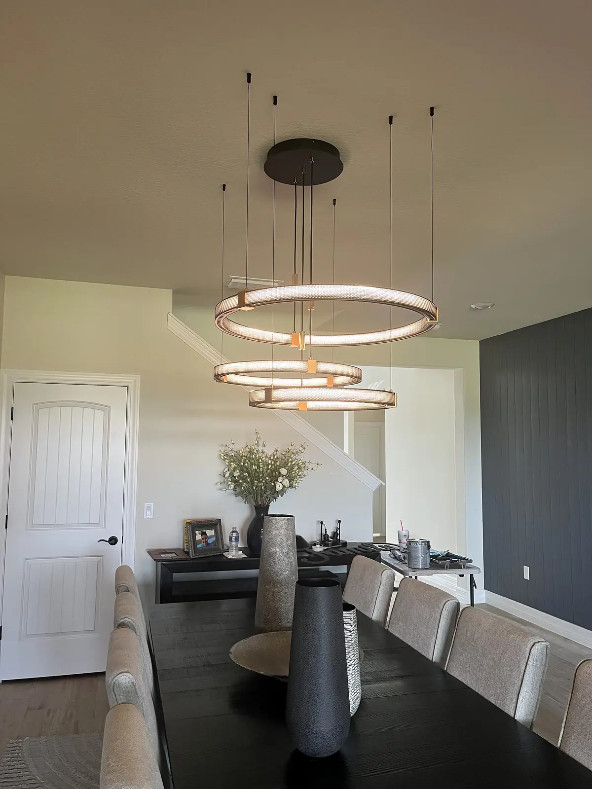 Wide room view of a modern ring pendant over a dining table