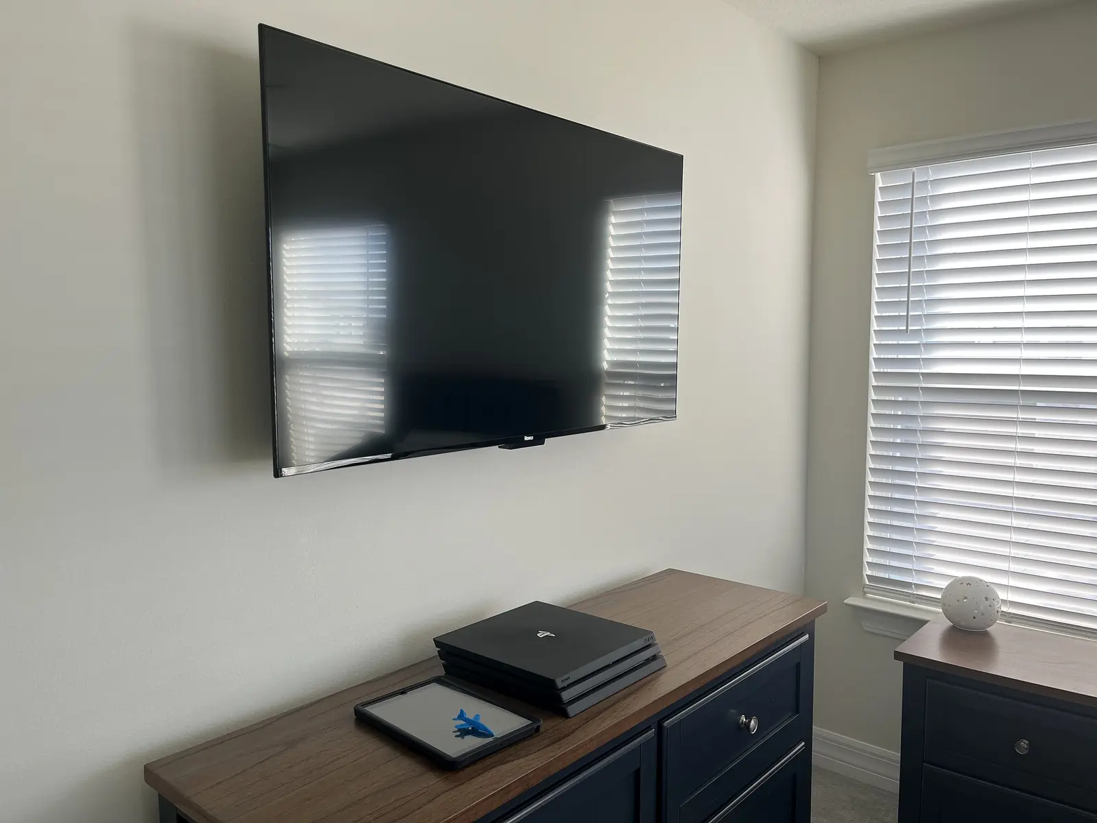 Wall-mounted bedroom television above accessible media equipment
