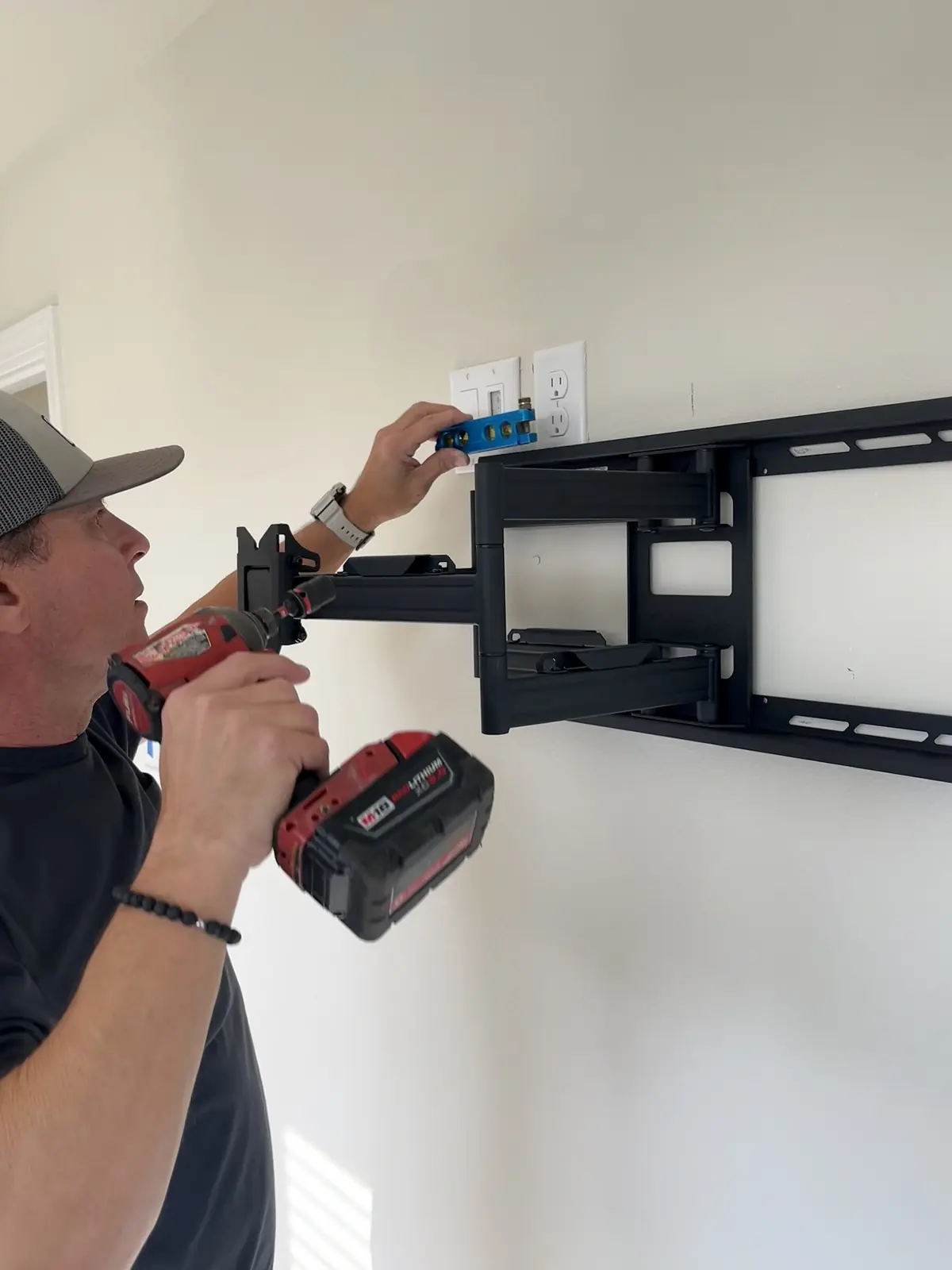 Technician checking television bracket hardware and alignment