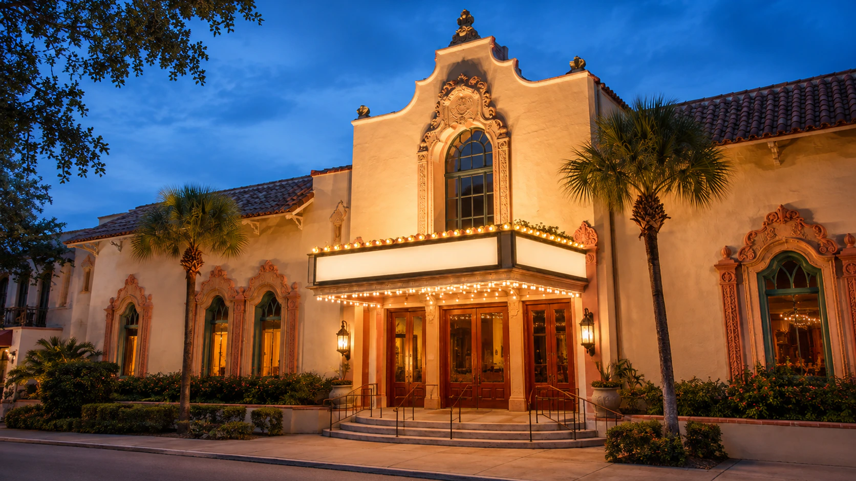 Historic Cocoa Village Playhouse exterior at blue hour with warm architectural lighting and an empty entrance