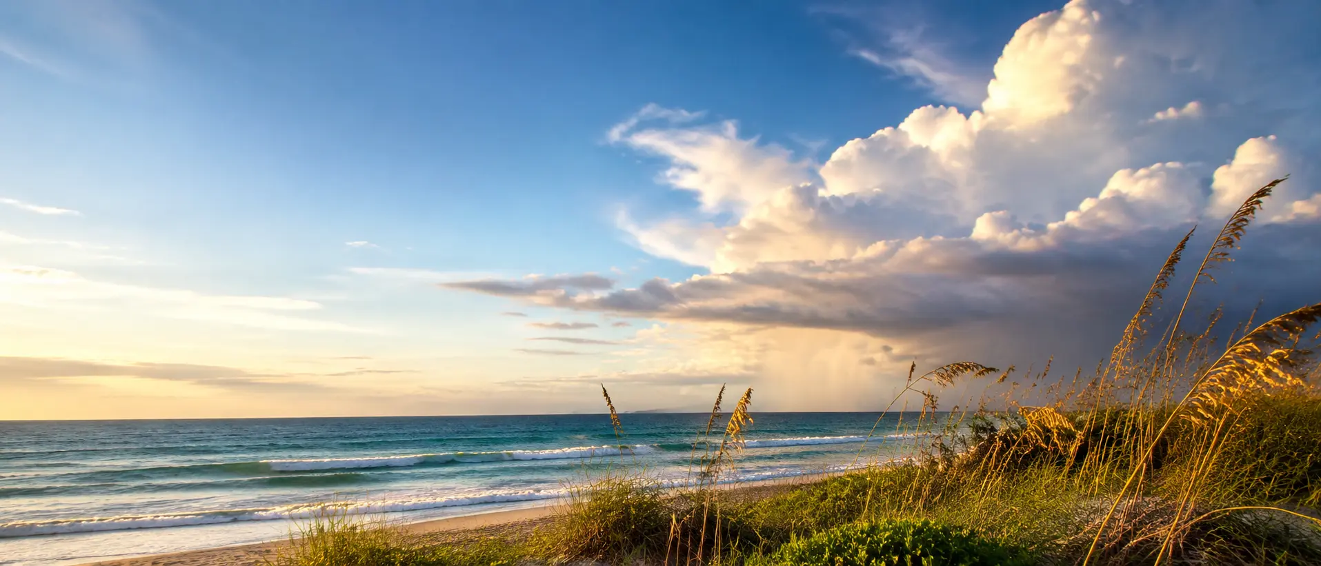 Sunlit Atlantic beach beneath building coastal clouds on Florida’s Space Coast