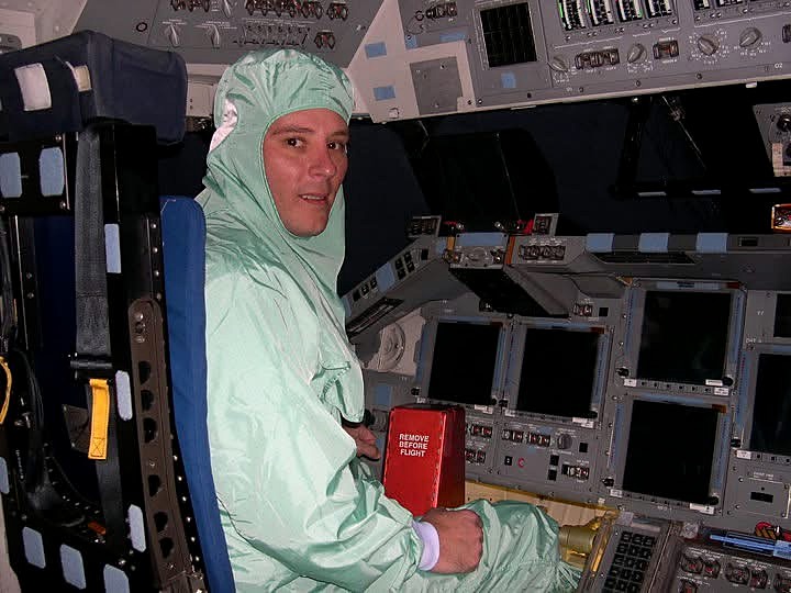 techX lead technician wearing required protective static-control attire inside the cockpit of Space Shuttle orbiter Atlantis